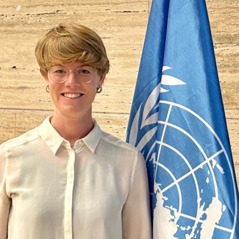 Profile photo of Anna Kroger in front of the UN flag